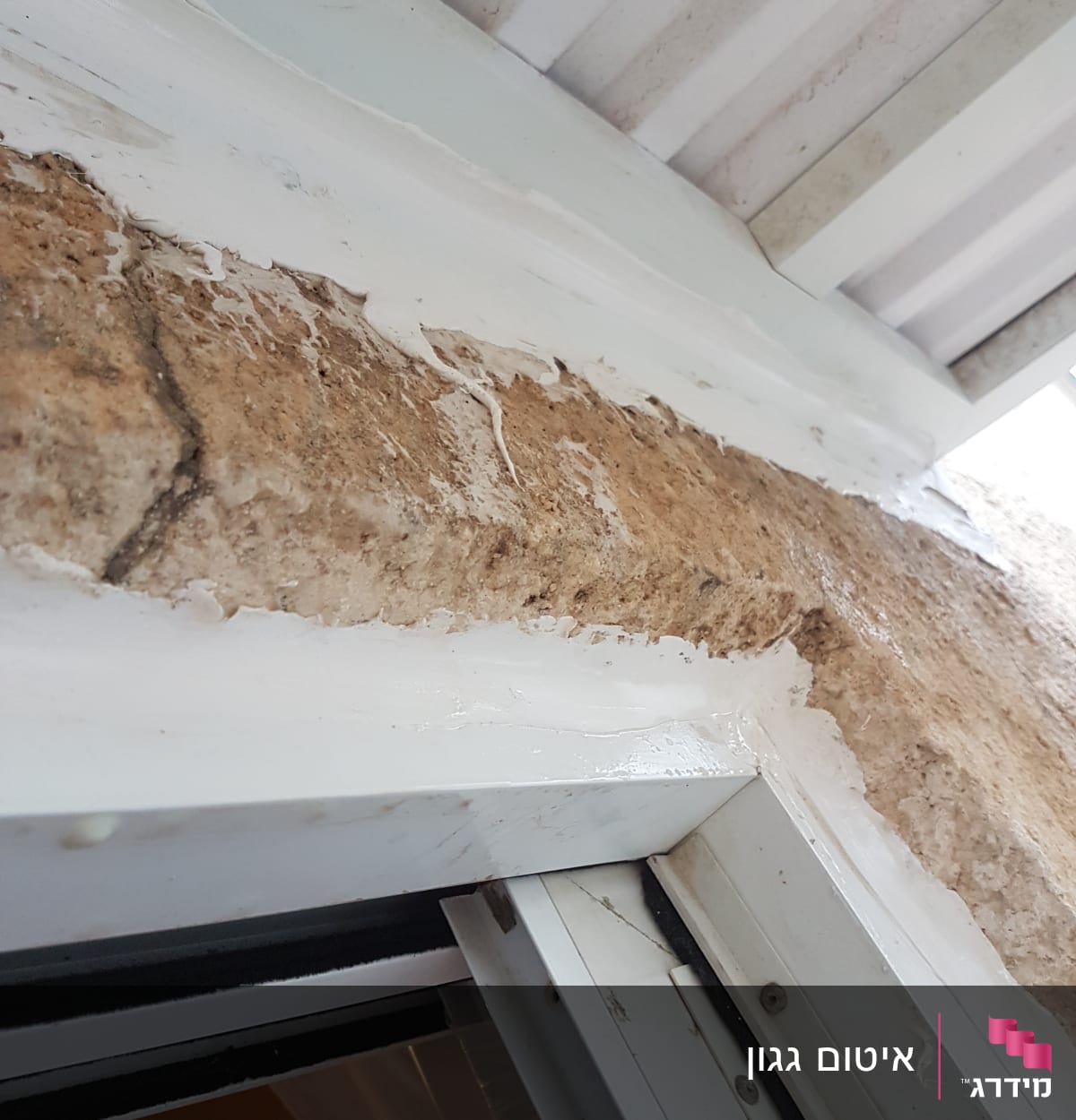 איטום חלון עם חומר לבן על מסגרת מתכת